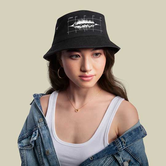 Nyfiken på nu 10 En fotomodell med en svart hatt med vitt Gageego!-tryck på.